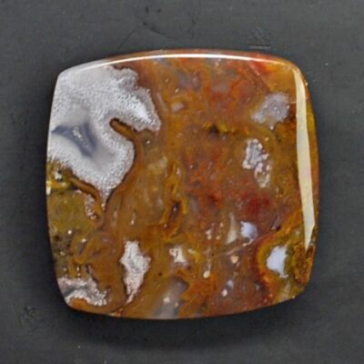 A square piece of agate on a black surface.