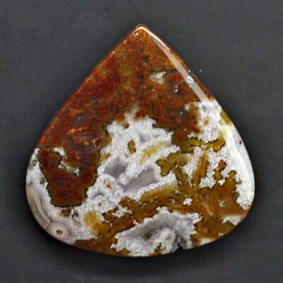 A brown and white agate pendant on a black surface.