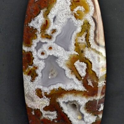 A brown and white agate pendant on a black surface.