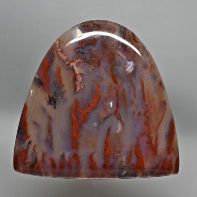 A piece of agate with a red and brown pattern.