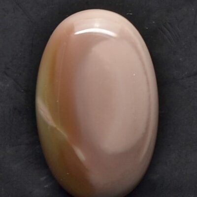 An oval agate stone on a black surface.