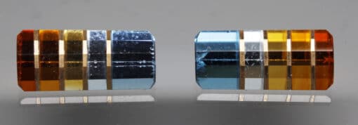 Two pieces of colored glass on a gray surface.