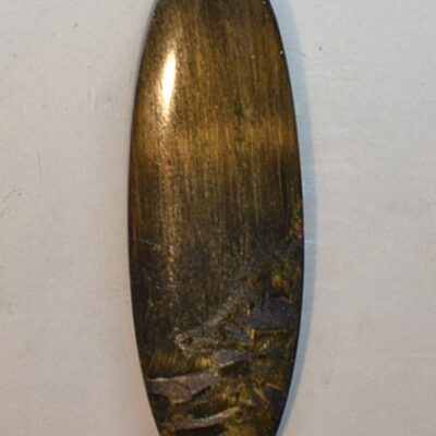 A tiger's eye cabochon on a white surface.