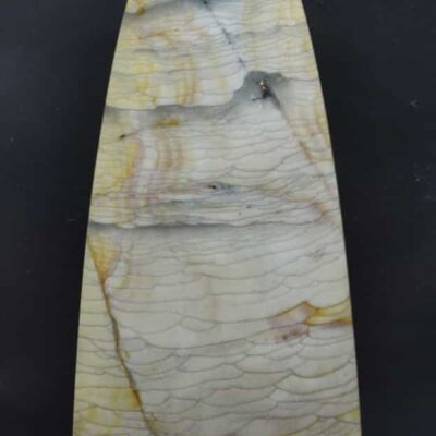 A large piece of yellow and white marble on a black background.