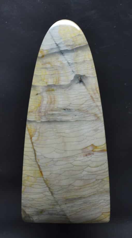 A large piece of yellow and white marble on a black background.