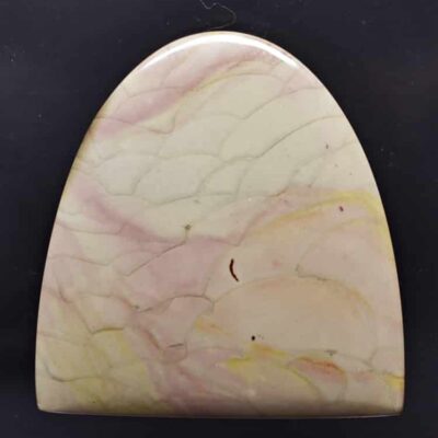 A piece of pink and yellow marble on a black surface.