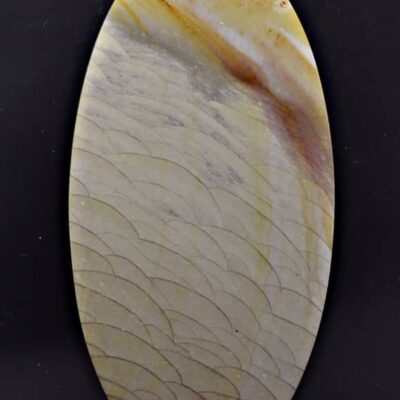 A round piece of agate on a black surface.