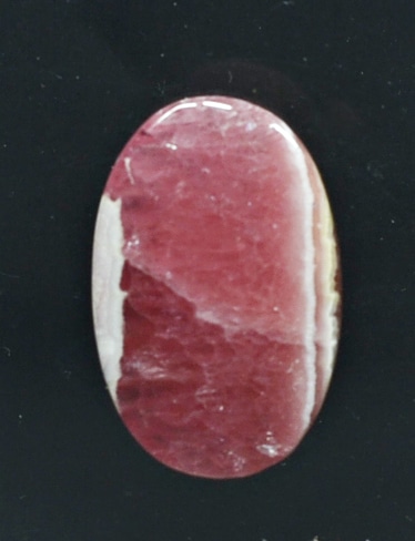 A piece of red agate on a black surface.