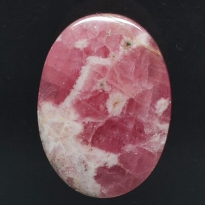 A pink and white stone cabochon on a black background.