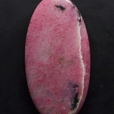 A pink stone with black spots on it.
