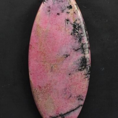 A pink stone pendant on a black surface.