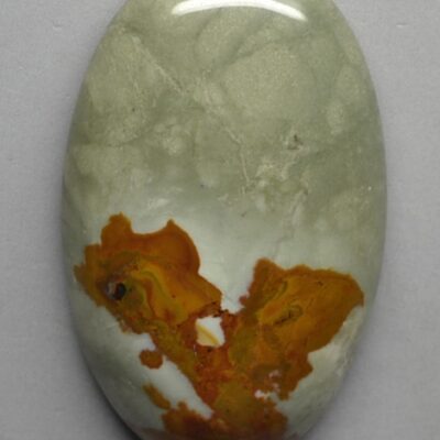 A piece of jade with orange and yellow paint on it.