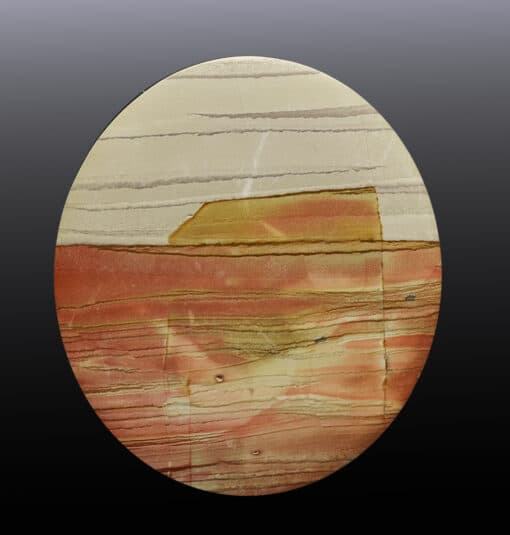 A circular piece of stone with a red, yellow, and brown color.