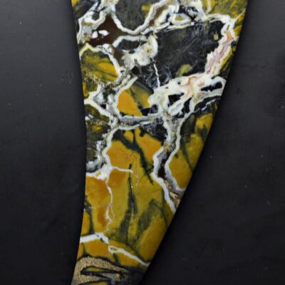 A yellow and black marble sculpture on a black background.