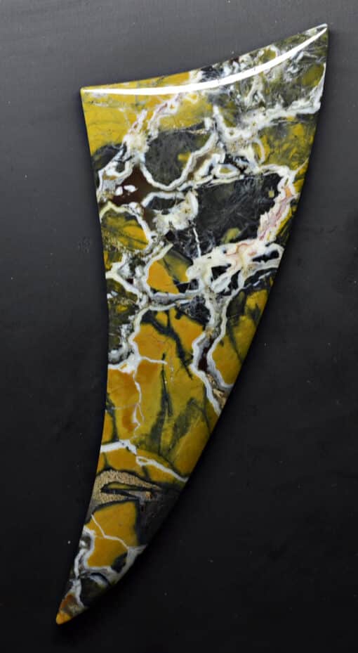 A yellow and black marble sculpture on a black background.
