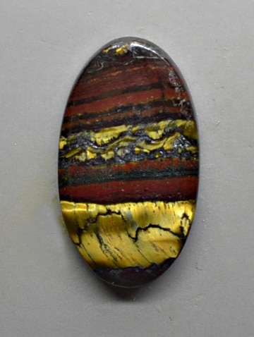 An oval shaped piece of tiger's eye stone.