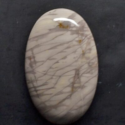 A white and brown marble stone on a black surface.