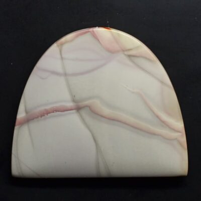 A white and pink marble plate on a black surface.
