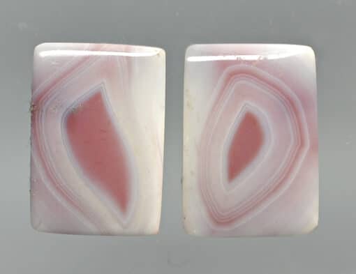 A pair of pink and white agate cabochons.