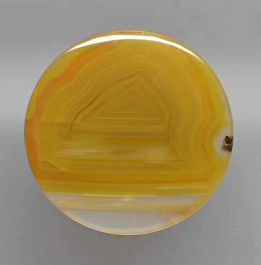 A yellow agate disk on a white background.