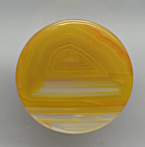 A yellow agate disk on a white surface.