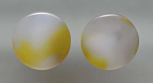 A pair of yellow and white agate cabochons.