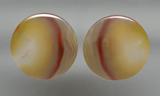 A pair of yellow and orange agate stud earrings.