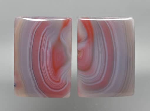 A pair of pink and red agate cabochons.