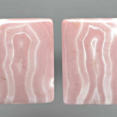 A pair of pink agate slabs on a gray surface.