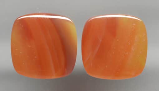 A pair of orange agate cabochons.