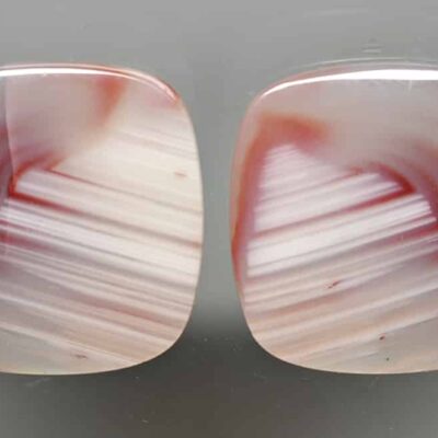 A pair of red and white agate cabochons.