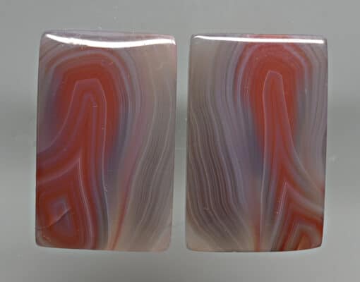A pair of red and white agate cabochons.