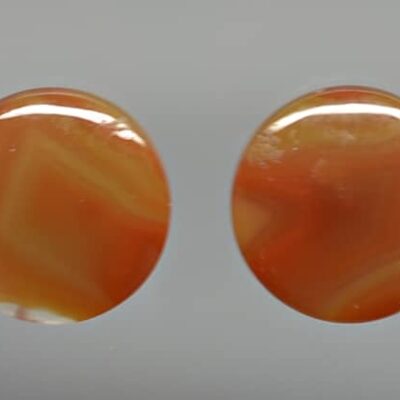 A pair of orange agate oval cabochons.
