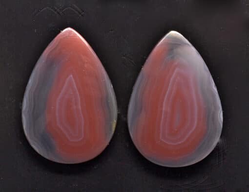 A pair of red and white agate tear shaped cabochons.