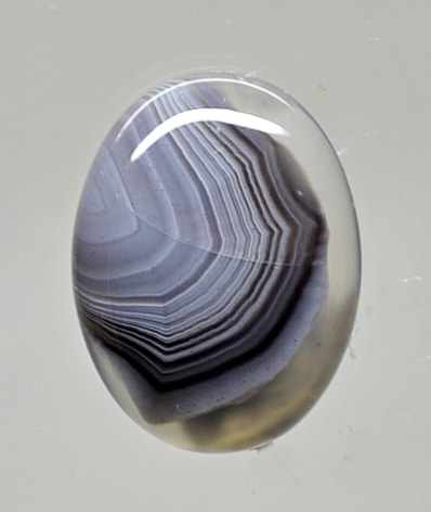 An oval agate stone on a white surface.