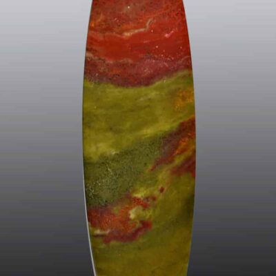 A red, yellow and green marble oval on a black background.