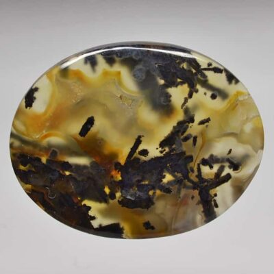 A round piece of agate with black and yellow swirls.