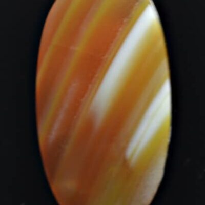 An orange and white striped agate cabochon on a black background.