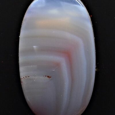 A blue and white agate cabochon on a black background.