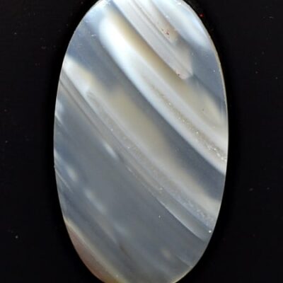 A white agate oval cabochon on a black background.