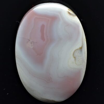 A pink and white agate pendant on a black background.