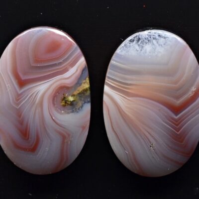 Two oval pieces of agate with swirls on them.