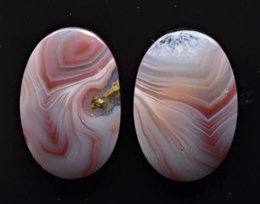 Two oval pieces of agate with swirls on them.