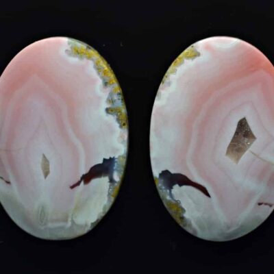Two pink agate oval cabochons on a black background.
