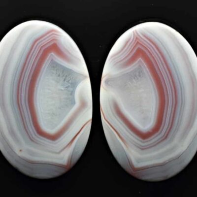 A pair of white and red agates on a black background.