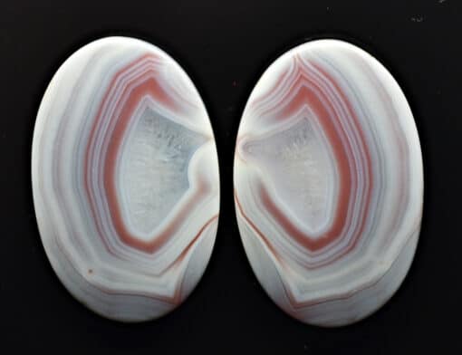 A pair of white and red agates on a black background.