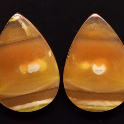 A pair of orange and yellow agate tear shaped cabochons.