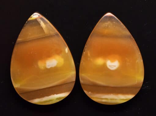 A pair of orange and yellow agate tear shaped cabochons.