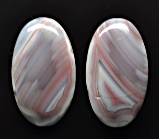 Two oval agate cabochons on a black background.