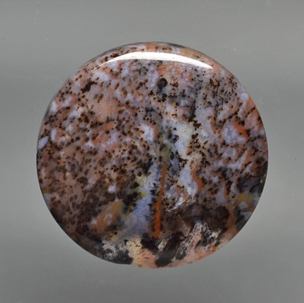 A piece of brown and orange jasper on a gray background.